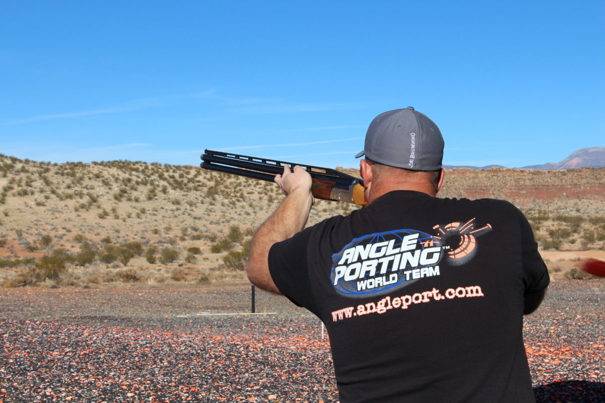 Man Aiming Shotgun into Blue Sky