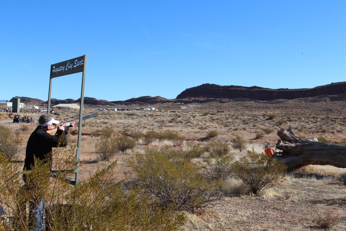 Wide View of Man Aiming Shotgun